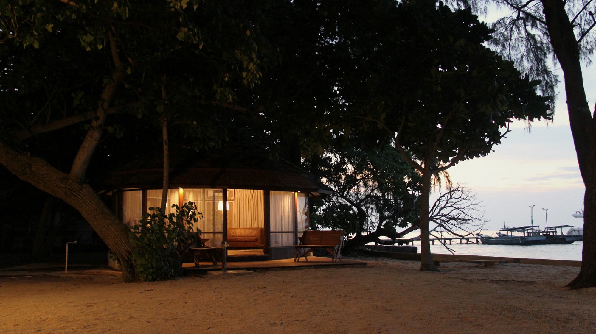 bungalow at dusk, warm interior glow.